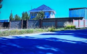 科奇科尔Guest House Umar的街道前有围栏的房子