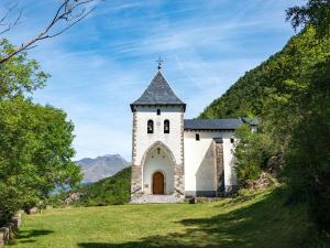 ガビンにあるApartamentos Gavín Biescas 3000の草原の上に塔のある小さな教会