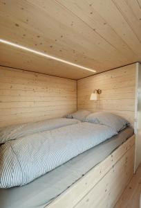 a bed in a wooden cabin with a wooden wall at Waterfront Loft in Brandenburg an der Havel