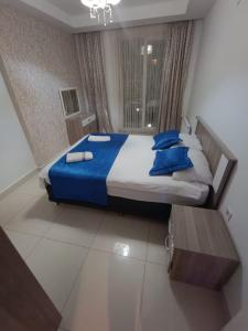 a bedroom with a large bed with blue pillows at AQUA CİTY SUİT in Antalya