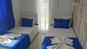 two beds in a room with blue and white at AQUA CİTY SUİT in Antalya
