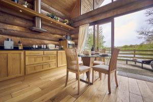 uma cozinha com mesa e cadeiras e uma grande janela em Alder Lodge with Hot-tub em Carlisle