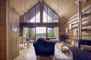 uma sala de estar com paredes de madeira e uma grande janela em Alder Lodge with Hot-tub em Carlisle