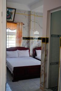 a bedroom with a bed and a mirror in it at Hoa Bien Motel in Ly Son