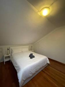 雪梨的住宿－Comfortable 3 Bedroom House Pyrmont，卧室配有白色的床和帽子