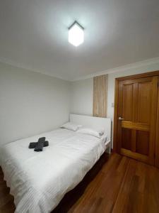 シドニーにあるComfortable 3 Bedroom House Pyrmontの白いベッドと木製のドアが備わるベッドルーム1室が備わります。