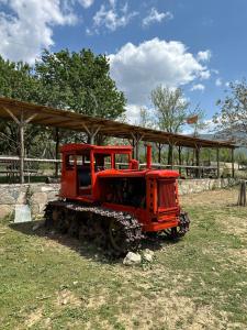 a red train engine sitting in the grass at VILA DISHA in Tirana