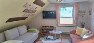 een woonkamer met een bank en een tv bij Ferienwohnung Lucke in Luftkurort Lückendorf