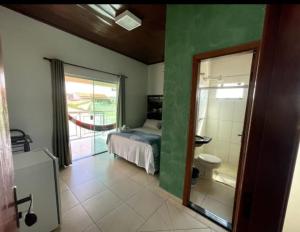 um quarto com um quarto com uma cama e uma casa de banho em Pousada Caminho das Cachoeiras Pirenopolis em Pirenópolis