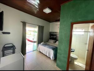 um quarto com uma cama e uma casa de banho com um WC em Pousada Caminho das Cachoeiras Pirenopolis em Pirenópolis