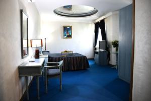 een hotelkamer met een bed, een bureau en een wastafel bij Aquapark Hotel & Villas in Jerevan