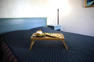 Aquapark Hotel & Villas في يريفان: صينية طعام على طاولة على سرير