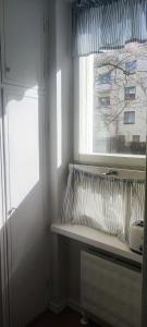 una ventana en una habitación con una almohada en un estante en Eskolampi en Helsinki