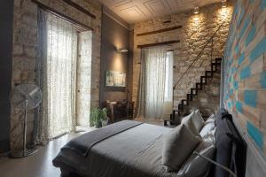 una camera con un grande letto e alcune finestre di ArtStudio6 Dimora Artistica a Campobasso