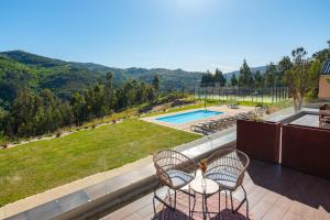 a balcony with two chairs and a view of a pool at Quinta de Cabanas Douro - By Unlock Hotels in Penha Longa