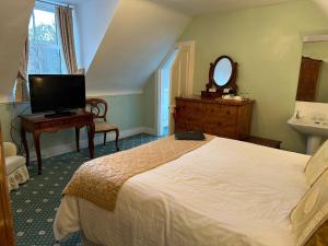 a bedroom with a bed and a sink and a mirror at Ravenscourt House, Guest House & Restaurant in Grantown on Spey