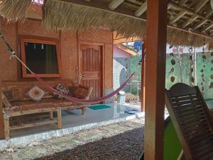 a hammock on the outside of a house at Pelangi Homestay Bungalow Gili gede in Sekotong
