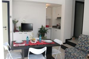 a living room with a table and chairs and a television at Residence Sangiorgi in Cattolica