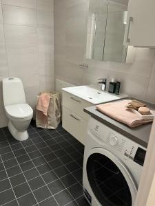 La salle de bains est pourvue d'un lave-linge et de toilettes. dans l'établissement Modern and Chic Lindholmen Central Apartment, à Göteborg