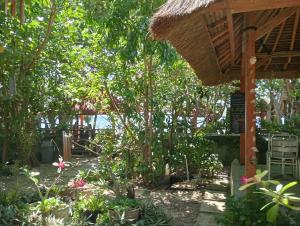 um jardim com um pavilhão e algumas plantas em Pelangi Homestay Bungalow Gili gede em Sekotong