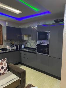 a kitchen with stainless steel appliances and a green light at Riad Targante Takate 1 in Sidi Bibi
