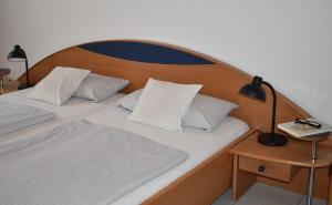 Una cama con almohadas blancas y una lámpara en una mesa. en Ferienwohnung Reis, en Sankt Aldegund