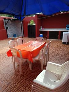 a table and chairs with an orange table and umbrella at منزل كامل قرب شاطئ بوزنيقة in Kasba Bou Hamira +6 photos
