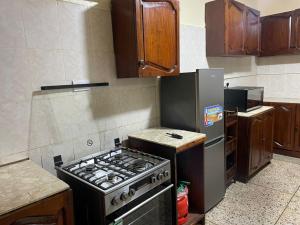 uma cozinha com um fogão e um frigorífico em Tranquility three bedroom house with Wi-Fi em Dar es Salaam