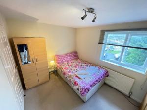 a small bedroom with a bed and a window at Solo Lodge in Windsor & Legoland in Windsor