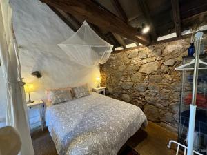 1 dormitorio con cama y pared de piedra en Finca La Principal, en Breña Alta
