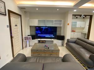 Il comprend un salon doté d'un canapé et d'une télévision à écran plat. dans l'établissement Corner New Private Pool Villa Near Sunway up to 30 pax, à Subang Jaya