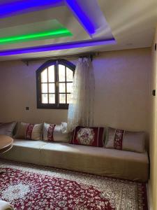 a large couch in a room with a window at Riad Targante Takate 1 in Sidi Bibi