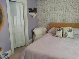a bedroom with a bed with a pillow and a chair at The Old Rectory in Dorchester