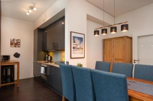 a kitchen with blue chairs and a counter at Holiday at Alexanderplatz Apartments in Berlin