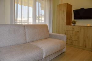 a living room with a couch and a television at Sea Legends in Nea Vrasna