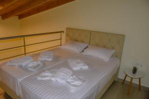 a bedroom with a bed with white towels on it at Sea Legends in Nea Vrasna