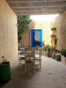 a patio with a table and chairs and potted plants at Riad Targante Takate 1 in Sidi Bibi