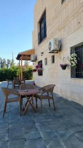a patio with a table and chairs next to a building at Caprios motel in Al Qasţal