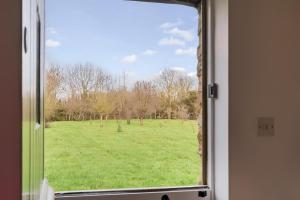 a view of a field from a window at Orchard Cottage: Lake Access & Facilities On-site in Somerford Keynes