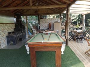 a pool table on a deck with a house at Cantinho da Roça in Cunha