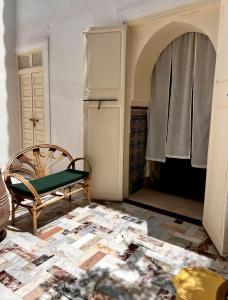 Habitación con silla y nevera. en Riad Tizwa Marrakech, en Marrakech