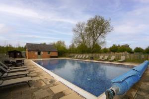 a large swimming pool with a large blue inflatable at Orchard Cottage: Lake Access & Facilities On-site in Somerford Keynes