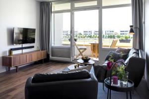 een woonkamer met een bank en een tv bij Ferienwohnung Stranddistel am Südstrand in Fehmarn