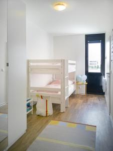 een slaapkamer met 2 stapelbedden en een tapijt bij Ferienwohnung Stranddistel am Südstrand in Fehmarn