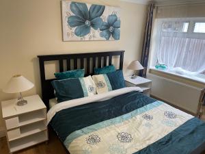 1 dormitorio con 1 cama con almohadas azules y blancas en Love & Peace, en Orpington