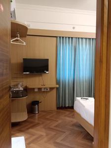 um quarto de hotel com uma cama e uma televisão em Krishna Inn em Bangalore