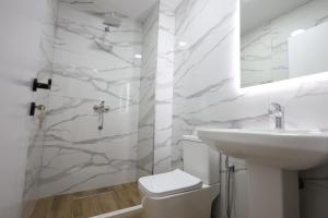 ein weißes Bad mit einem Waschbecken und einem WC in der Unterkunft Guesthouse Aurel in Berat