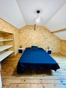 a bedroom with a blue bed in a stone wall at appartement 2 pieces in Aurillac