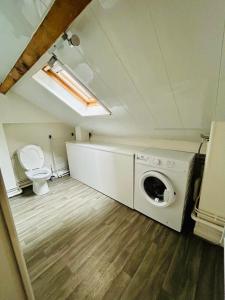 a washing machine in a room with a toilet at appartement 2 pieces in Aurillac