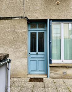 a blue door and a window on a building at appartement 2 pieces in Aurillac